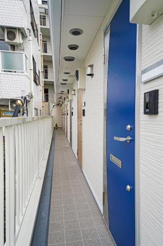 a hallway of a hospital with a blue door at Blue Empire Hotel in Tokyo