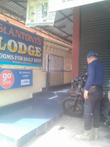 a man standing next to a motorcycle in a garage at St. Antonys Lodge in Cochin