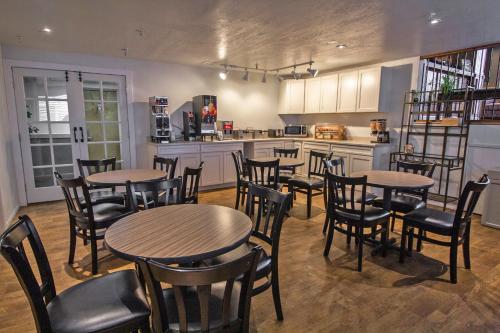 a restaurant with tables and chairs and a kitchen at FairBridge Inn - Coeur d'Alene in Coeur d'Alene