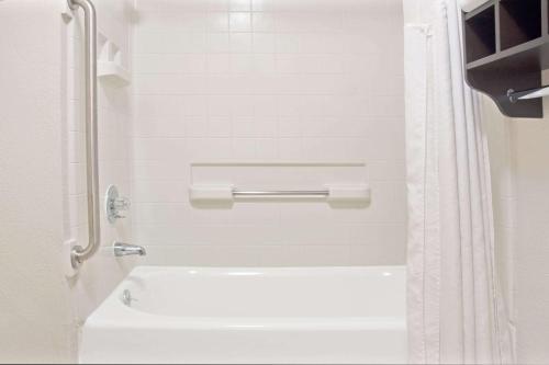 a bathroom with a white tub and a toilet at Howard Johnson by Wyndham Houston Heights Downtown in Houston