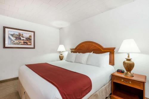 a hotel room with a bed and two lamps at Ramada by Wyndham State College Hotel & Conference Center in State College