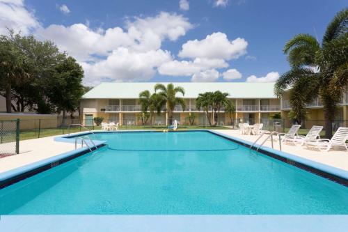 uma grande piscina em frente a um hotel em Howard Johnson by Wyndham Vero Beach / Downtown em Vero Beach