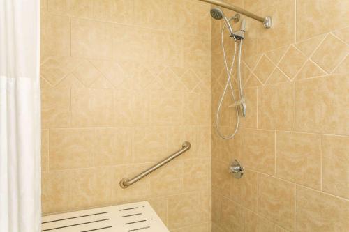 Un baño con ducha con cortina de ducha. en Ramada by Wyndham Houma, en Houma