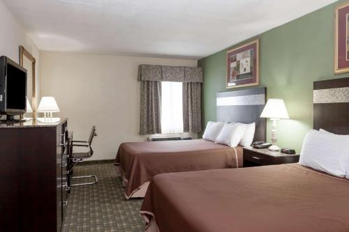 a hotel room with two beds and a television at Howard Johnson by Wyndham Newark Airport in Newark