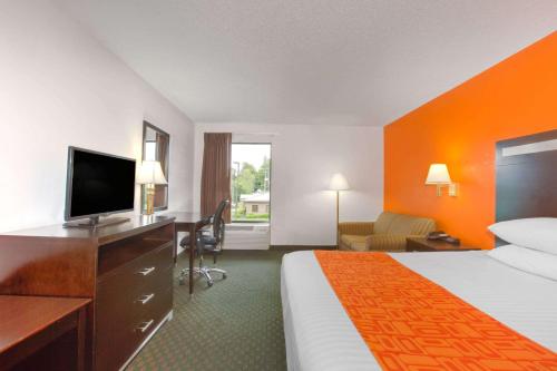 a hotel room with a bed and a flat screen tv at Howard Johnson by Wyndham Beckley in Beckley