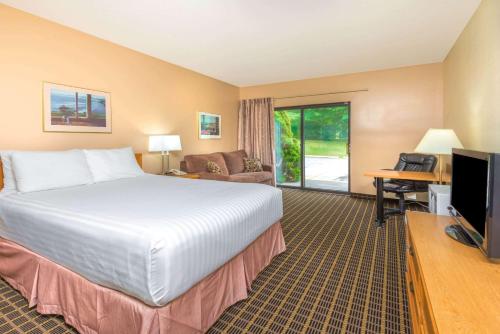 a hotel room with a large bed and a television at Howard Johnson by Wyndham Tillsonburg in Tillsonburg