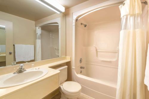 a bathroom with a sink and a toilet and a shower at Howard Johnson by Wyndham Tillsonburg in Tillsonburg