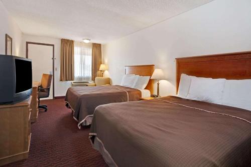 A bed or beds in a room at Howard Johnson by Wyndham Tallahassee