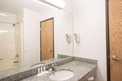a bathroom with a sink and a large mirror at Howard Johnson by Wyndham Beckley in Beckley