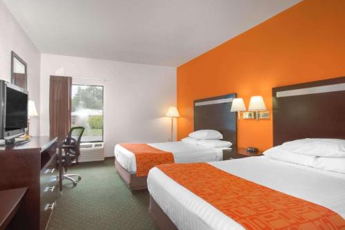 a hotel room with two beds and a flat screen tv at Howard Johnson by Wyndham Beckley in Beckley