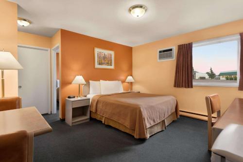 pokój hotelowy z łóżkiem i oknem w obiekcie Travelodge by Wyndham Quesnel BC w mieście Quesnel