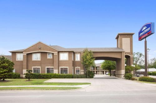 a building with a sign in front of it at Howard Johnson by Wyndham Grand Prairie Near Lone Star Park in Grand Prairie