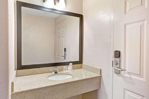 a bathroom with a sink and a mirror at Howard Johnson by Wyndham Galveston in Galveston