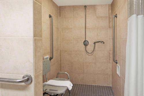 a bathroom with a shower with a shower curtain at Ramada by Wyndham Saginaw Hotel & Suites in Saginaw