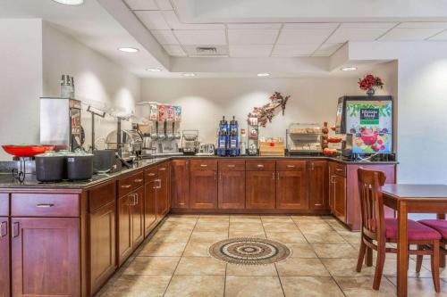 Una cocina grande con gabinetes de madera y una mesa. en Ramada by Wyndham Panama City, en Panama City