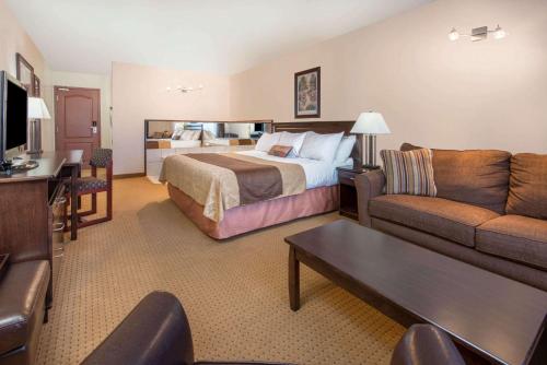 ロイドミンスターにあるGold Circle Innのベッドとソファ付きのホテルルーム