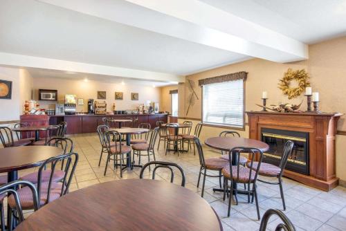a restaurant with tables and chairs and a fireplace at Gold Circle Inn in Lloydminster