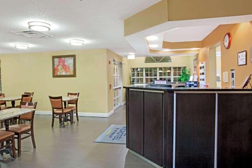 a restaurant with a bar and tables and chairs at Microtel Inn by Wyndham University Place in Charlotte