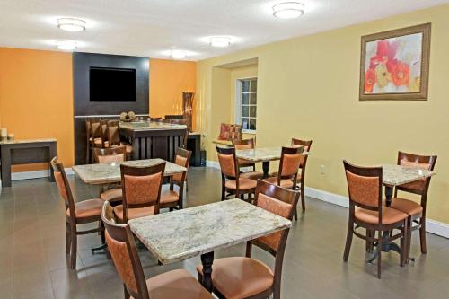 a restaurant with tables and chairs and a television at Microtel Inn by Wyndham University Place in Charlotte