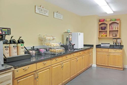 a kitchen with wooden cabinets and a counter top at Microtel Inn by Wyndham University Place in Charlotte