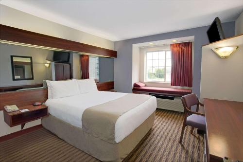 um quarto de hotel com uma cama grande e uma secretária em Microtel Inn by Wyndham - Murfreesboro em Murfreesboro