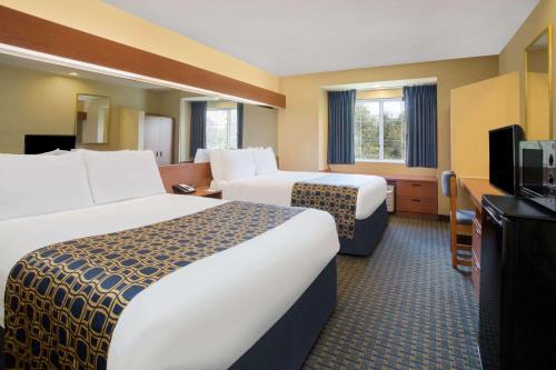 Tempat tidur dalam kamar di Microtel Inn & Suites Leesburg