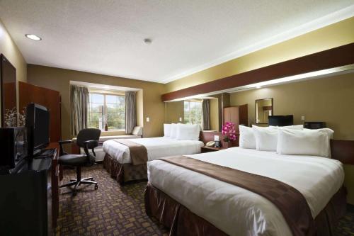 a hotel room with two beds and a television at Microtel Inn & Suites by Wyndham Lithonia/Stone Mountain in Lithonia