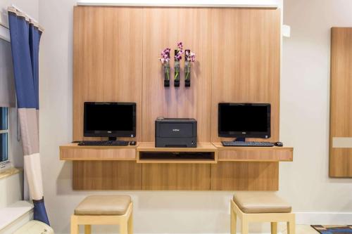 two computer monitors on a desk with two chairs at Microtel Inn & Suites by Wyndham Port Charlotte Punta Gorda in Port Charlotte