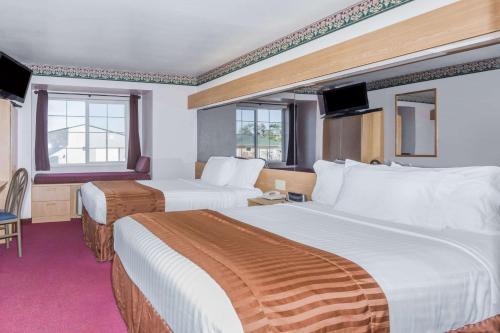 Habitación de hotel con 2 camas y 2 ventanas en Boarders Inn & Suites by Cobblestone Hotels - Brush, en Brush