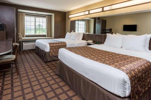 Microtel Inn & Suites by Wyndham Jacksonville Airport tesisinde bir odada yatak veya yataklar
