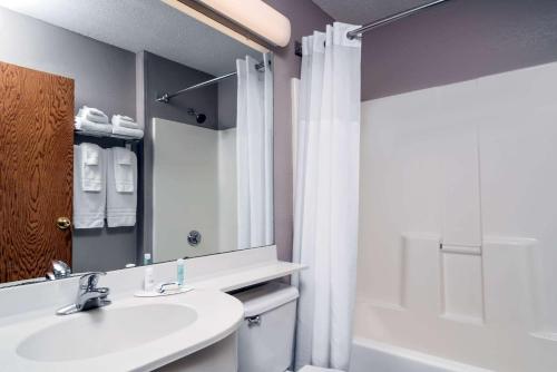 a bathroom with a sink and a tub and a shower at Microtel Inn & Suites by Wyndham New Ulm in New Ulm