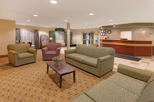 a lobby with couches and chairs and a piano at Microtel Inn & Suites by Wyndham Jasper in Jasper