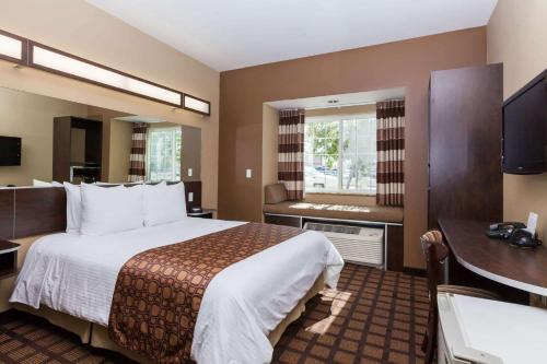 a hotel room with a large bed and a desk at Microtel Inn & Suites by Wyndham Wheeler Ridge in Wheeler Ridge