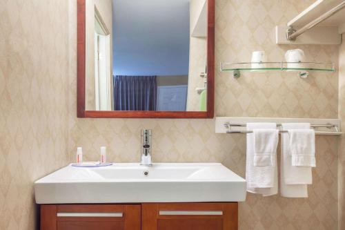 W łazience znajduje się umywalka, lustro i ręczniki. w obiekcie Howard Johnson Inn by Wyndham Kingston w mieście Kingston