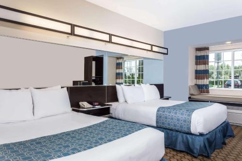 Microtel Inn & Suites by Wyndham Spring Hill/Weeki Wachee في ويكي واشي: غرفة فندقية بسريرين ونافذة