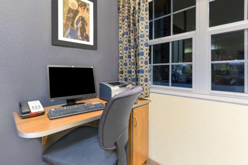 an office with a desk with a computer and a chair at Microtel Inn & Suites - Kearney in Kearney