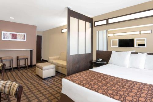 a hotel room with a bed and a couch at Microtel Inn & Suites in Sidney