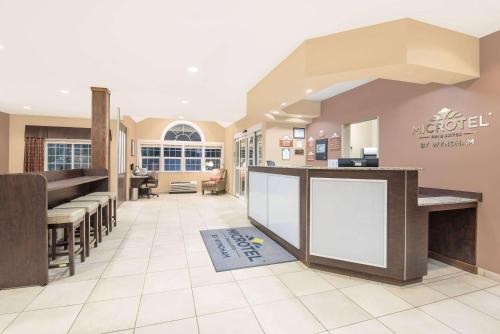 a lobby of a hospital with a counter and stools at Microtel Inn & Suites in Sidney