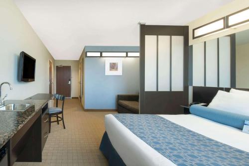 Cette chambre comprend un lit et un lavabo. dans l'établissement Microtel Inn & Suites by Wyndham Stanley, à Stanley