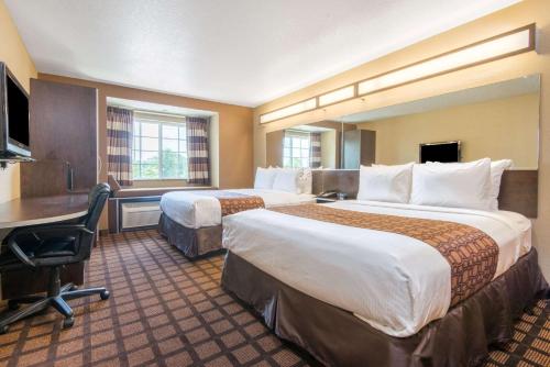 Un pat sau paturi într-o cameră la Microtel Inn and Suites Montgomery