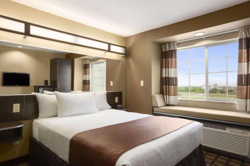 a hotel room with a large bed and a window at Microtel Inn & Suites Cotulla in Cotulla