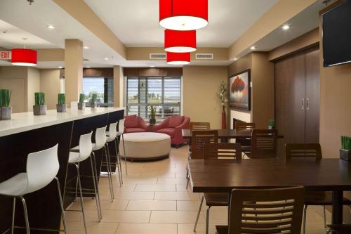 un ristorante con bar, tavoli e sedie di Microtel Inn & Suites by Wyndham Blackfalds a Blackfalds