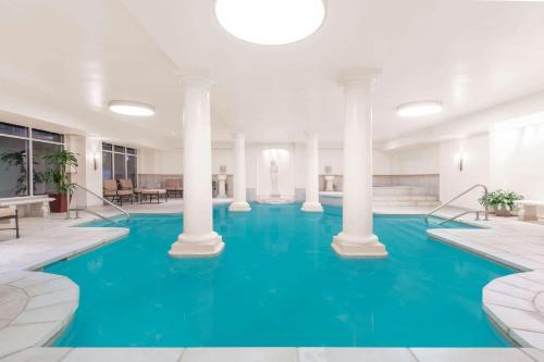 uma grande piscina com água azul num edifício em The George Washington - A Wyndham Grand Hotel em Winchester