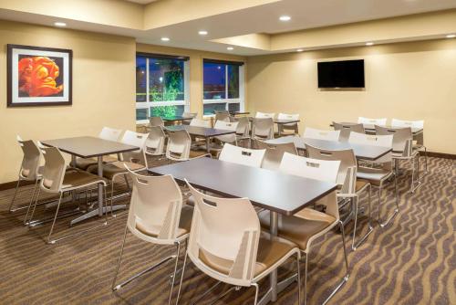 a conference room with tables and chairs and a flat screen tv at Microtel Inn & Suites by Wyndham Red Deer in Red Deer