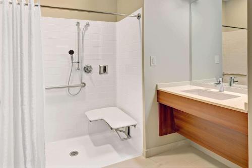 uma casa de banho com um chuveiro, um WC e um lavatório. em Microtel Inn & Suites by Wyndham Philadelphia Airport Ridley Park em Ridley Park