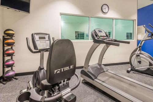 a gym with two cardio machines and a clock at Microtel Inn & Suites by Wyndham Altoona in Altoona