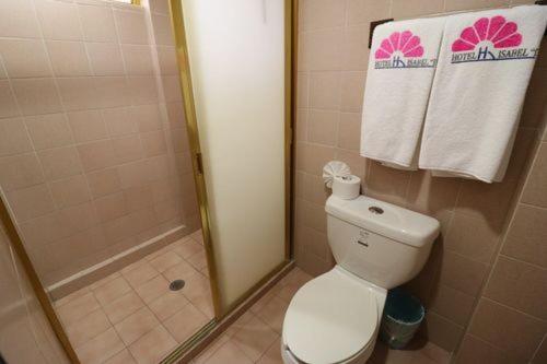 a bathroom with a toilet and a shower with towels at Hotel Isabel I in Oaxaca City