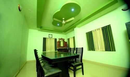 Un comedor con una mesa de cristal y sillas. en Bekal homestay and resorts, en Bekal