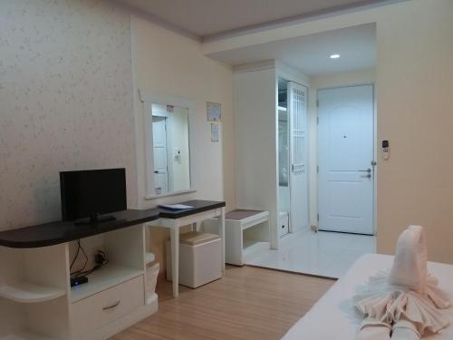 a white room with a television and a desk with a computer at Kradang Nga Boutique Inn in Khun Han