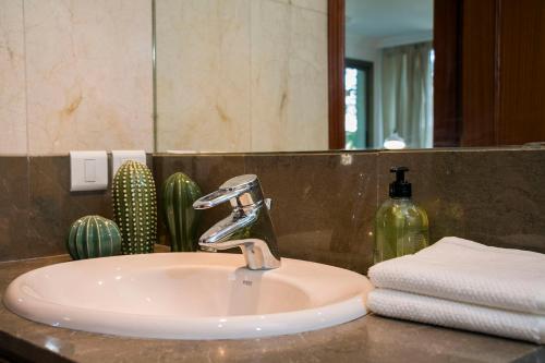 um lavatório de casa de banho com uma torneira e um espelho em NEW VIP piscina y gimnasio em Santa Cruz de Tenerife